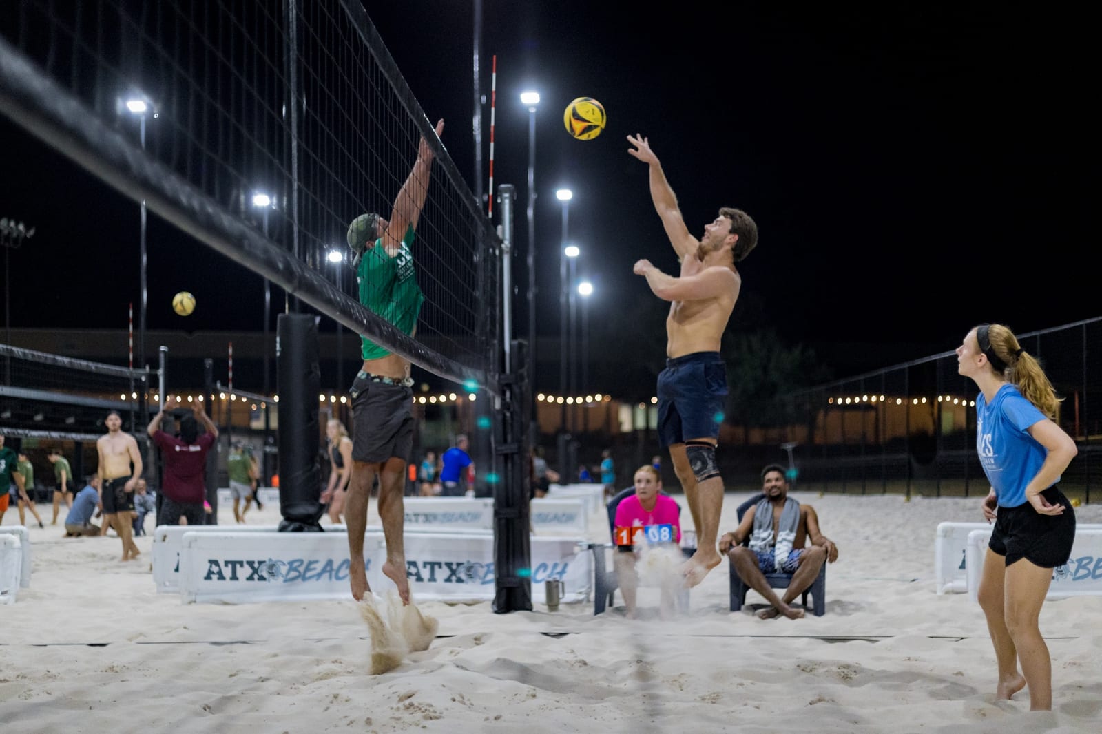 ACES players going up at the net during a sand volleyball match